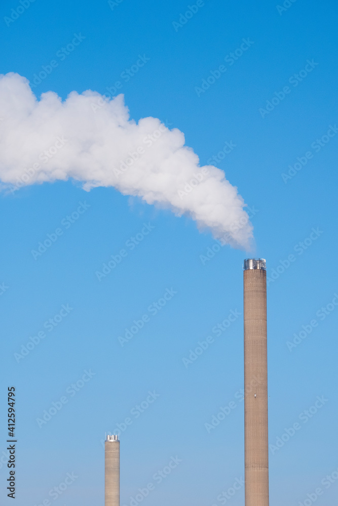 A closeup of an industrial smoke pipe against clear blue sky. A closeup of an industrial smoke pipe against clear blue sky.