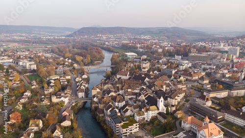 Drone view of cityscape Brugg north-east with Aare river, residential and commercial districts, historic old town and casino bridge in canton Aargau in Switzerland. Town situated on feet of Tafeljura. © Claudine