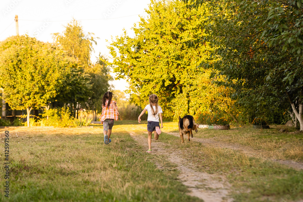 two little girls with dog running on the road two little girls with dog running on the road