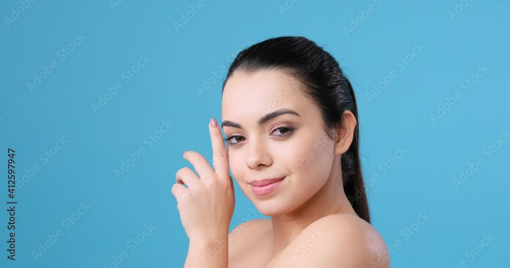 Beautiful naked woman with clean skin gently touching her cheek Beautiful naked woman with clean skin gently touching her cheek