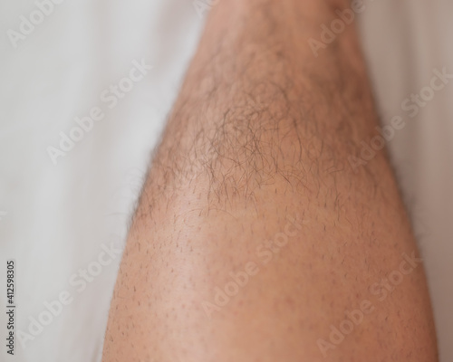 Close-up of a shaved half male leg.