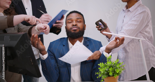 Calm young businessman meditate at business meeting avoiding pressure of annoying angry colleagues.