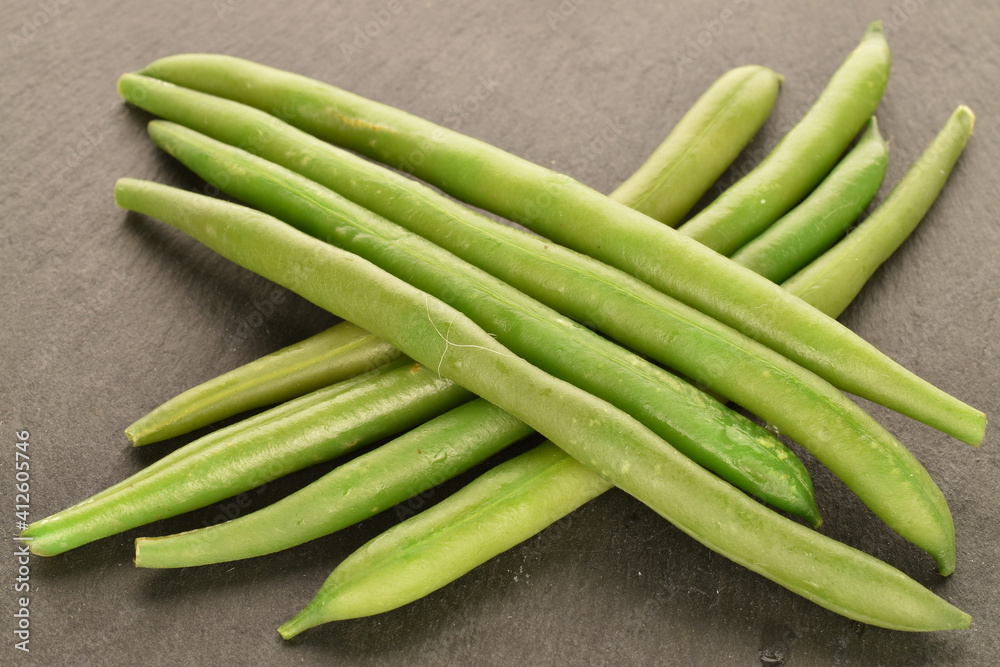 A few pods of bright green, organic, natural, ripe beans on a serving plate of slate. A few pods of bright green, organic, natural, ripe beans on a serving plate of slate.