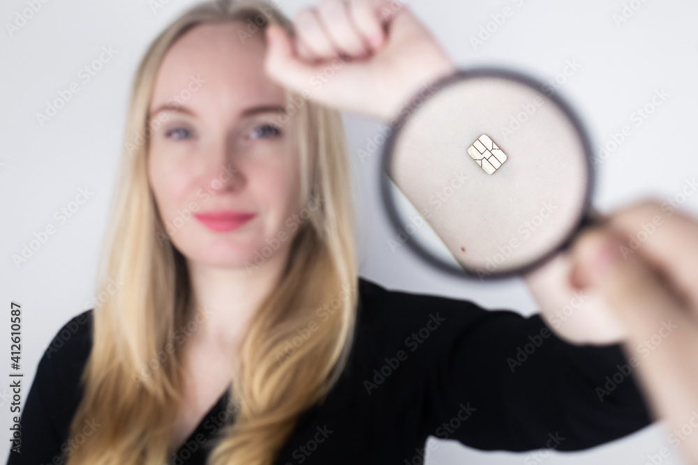 The woman shows his hand with a chip implanted which is studied with a magnifying glass. The