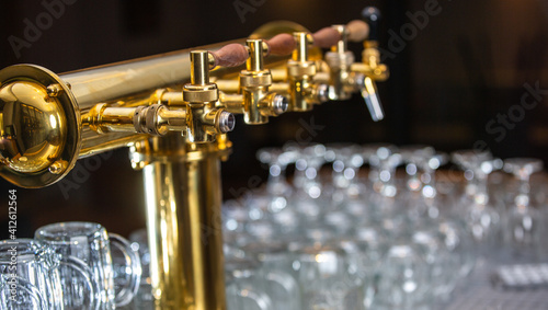 Close up of a beer faucet or tap with huge arrenge of an empty glasses in the bar or pub, restaurant concept