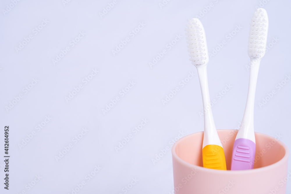 Closeup toothbrush in the glass isolated grey background. Copy space for text.