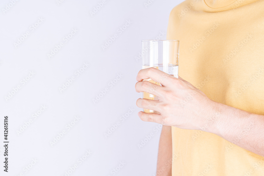 Man holding glass of water isolated grey background. Clean drinking water in clear glass. Man holding glass of water isolated grey background. Clean drinking water in clear glass.
