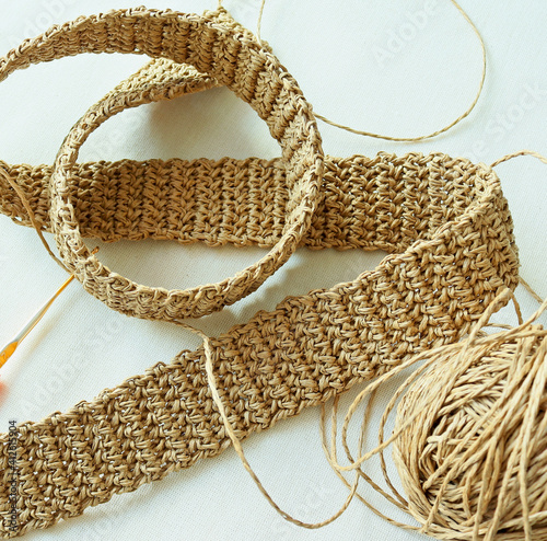 Obraz na plátně Photo of crocheting of waistband from raffia on fabric background