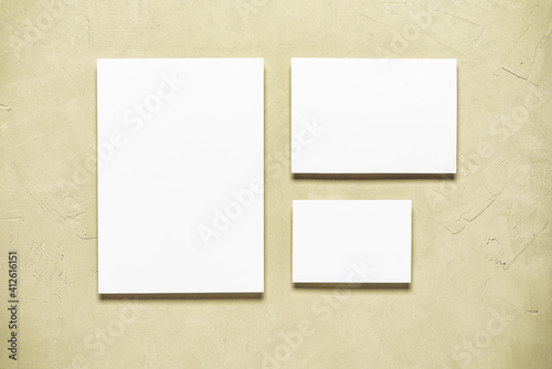 Blank paper white cards mockup on beige concrete background. Modern stationery scene. Template for your design. Top view, flat lay.