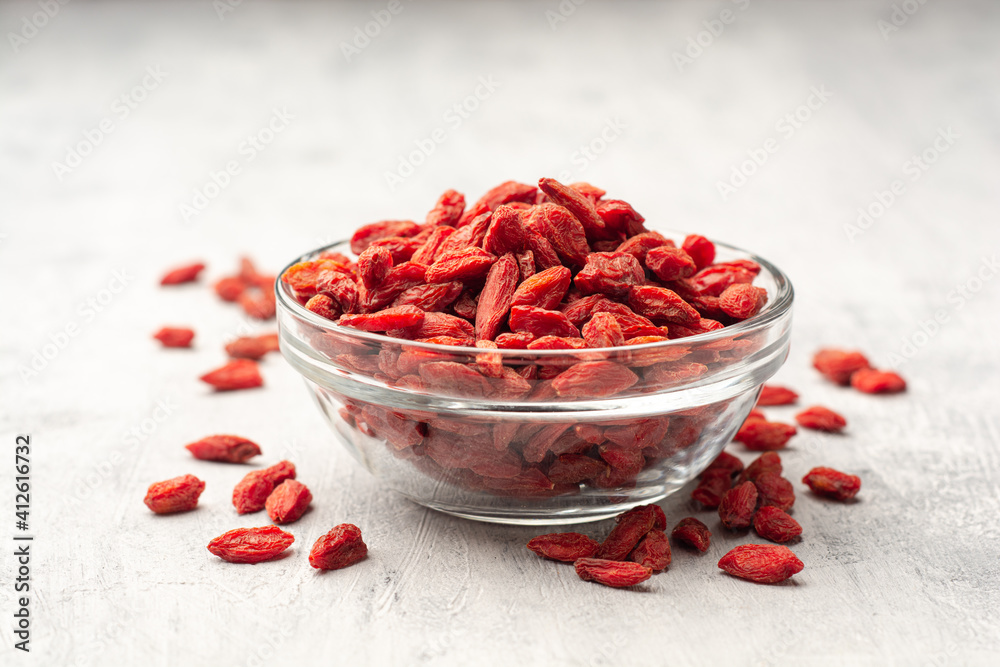 Dry goji berries in glass bowl on concrete background Dry goji berries in glass bowl on concrete background
