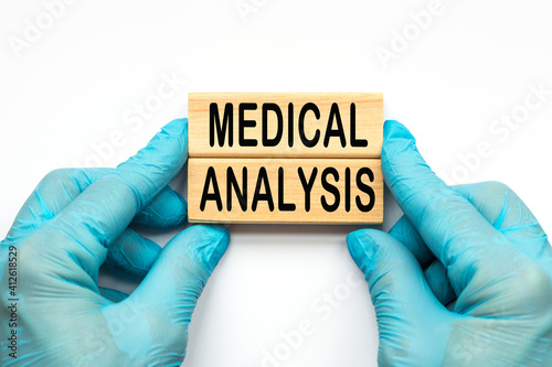 The doctor's hands show the words medical ANALYSIS . a gloved hand on a white background. Medical concept. the medicine