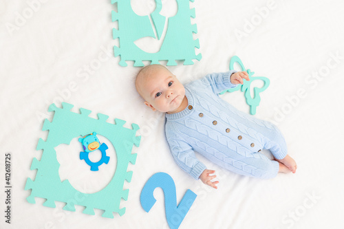 baby with a developing mat on the bed. Games for children. Baby's activity
