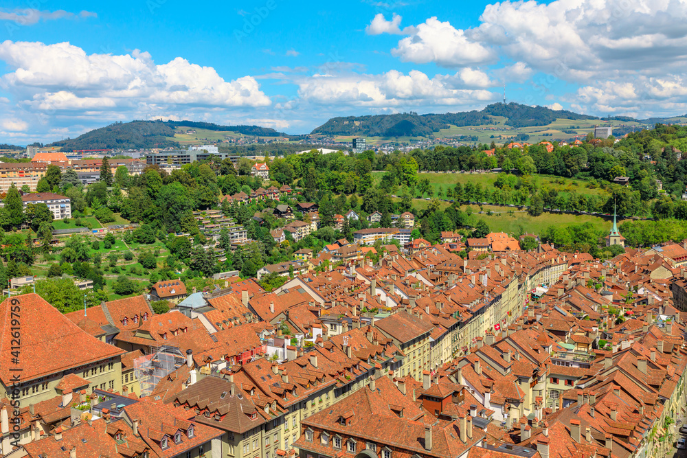 Panoramic view of Bern old town, Switzerland, UNESCO World Heritage Site since 1983 from Cathedral bell tower. Cityscape of medieval house roofs and Swiss Alps on background.