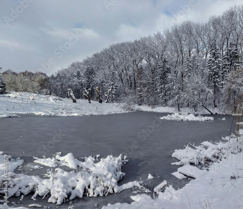 winter landscape with snow-covered trees and ice on the lake