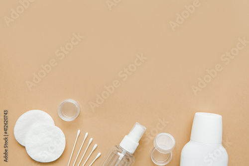 Skin care, beauty concept. Natural skin care products, bottles, cotton pads and soap on beige background. Free space for text.