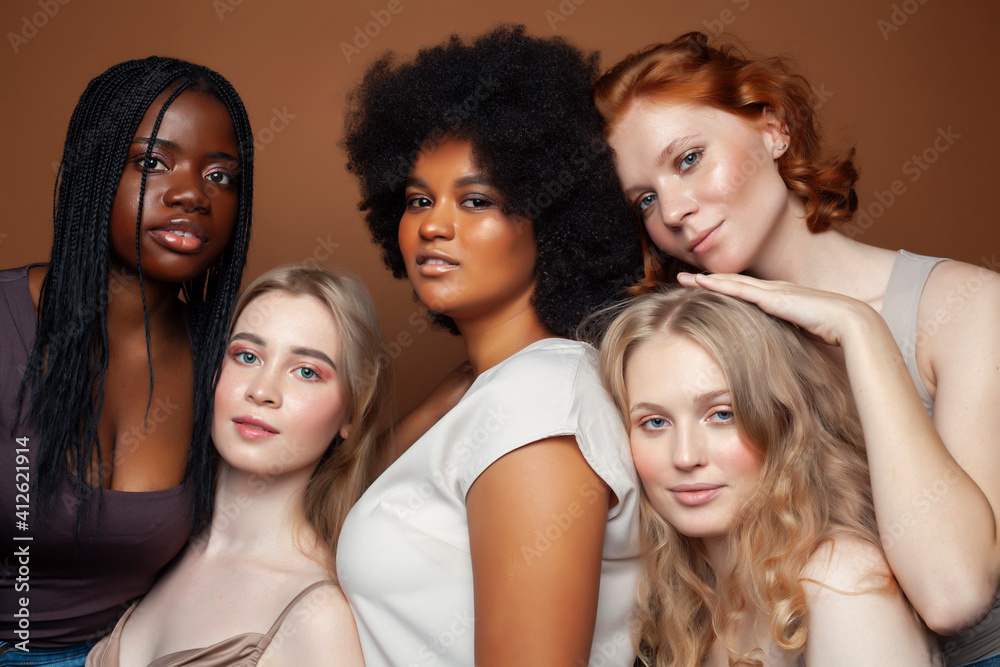 Obraz premium young pretty caucasian, afro, scandinavian woman posing cheerful together on brown background, lifestyle diverse nationality people concept