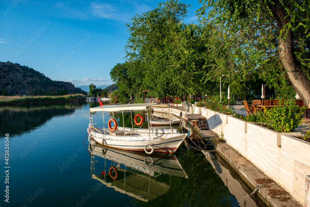 Obraz premium June13, 2020. Dalyan, Mugla - Turkey. Boats view at slope of Lycians rock tombs in Dalyan Town.