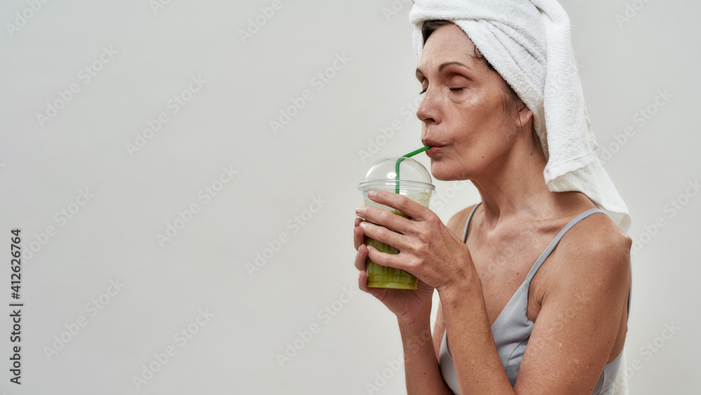 Beautiful middle aged woman drinking smoothie Beautiful middle aged woman drinking smoothie