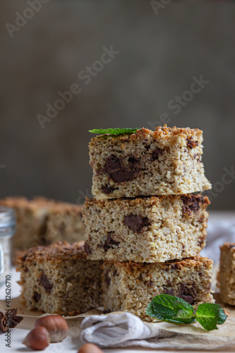 Oatmeal squares with chocolate decorated, light concrete background. Diet bars. Healthy bakery for breakfast or dessert.