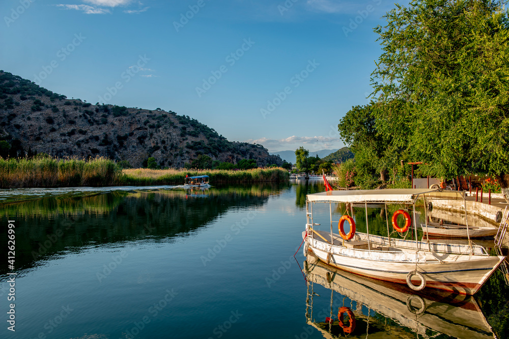 Obraz premium June13, 2020. Dalyan, Mugla - Turkey. Boats view at slope of Lycians rock tombs in Dalyan Town.