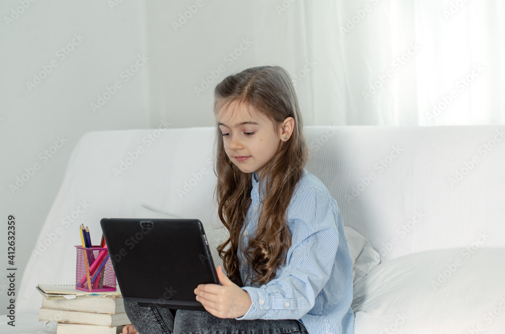 Little girl at an online lesson at home using a laptop copy space. Little girl at an online lesson at home using a laptop copy space.