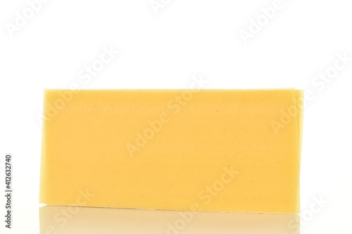 Several uncooked yellow lasagna sheets, close-up, isolated on white.