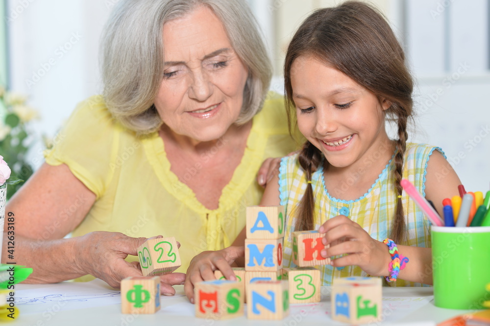 Portrait of grandmother and granddaughter with cubes Portrait of grandmother and granddaughter with cubes