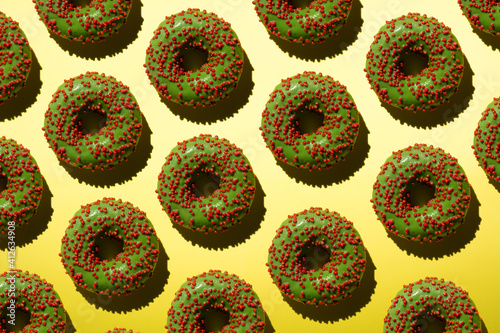Green donuts with red crumb on a yellow background