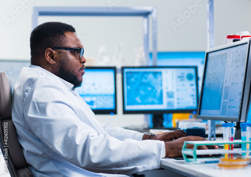 Professional African-American scientist is working on a vaccine in a modern scientific research laboratory. Genetic engineer workplace. Future technology and science.