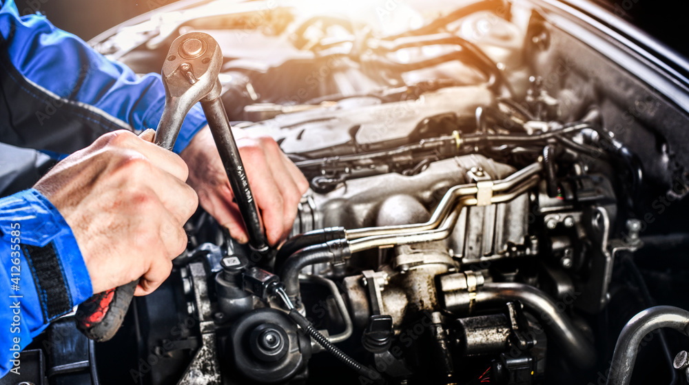 Auto mechanic working on car broken engine in mechanics service or garage. Auto mechanic working on car broken engine in mechanics service or garage.