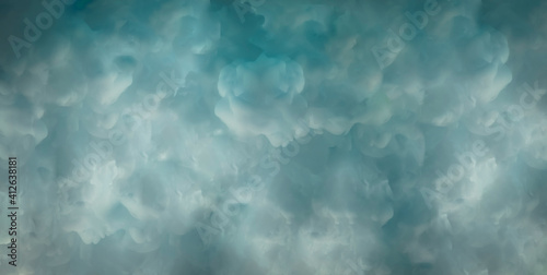 Beautiful liquid blue abstract background with colored paint in water like clouds.