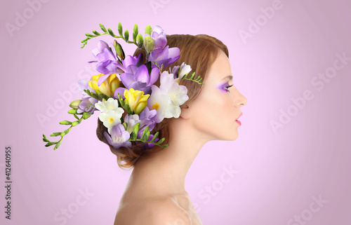 Fototapeta Naklejka Na Ścianę i Meble -  Pretty woman wearing beautiful wreath made of flowers on lilac background