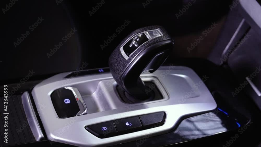 Close up of on automatic modern gear shift knob. The silver black gearshift of a luxurious car. Gearbox shift knob in sport car interior rail. Car interior parts. Car driving concept 4k