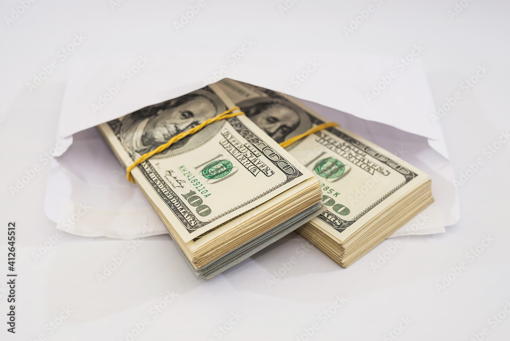two bundles of dollars tied with an elastic band in a white envelope on a white background two bundles of dollars tied with an elastic band in a white envelope on a white background