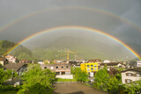 Doppelter Regenbogen über Dorf in der Schweiz
