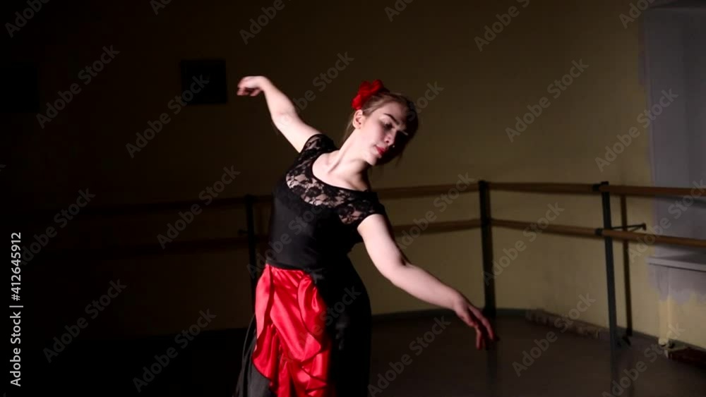 Young graceful ballerina dancing elements of classical ballet in the dark with light in the background. Beautiful young ballerina in the dark. Ballet practice in the studio Young graceful ballerina dancing elements of classical ballet in the dark with light in the background. Beautiful young ballerina in the dark. Ballet practice in the studio