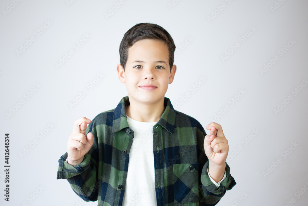 Portrait of boy shows crossed fingers isolated on white background