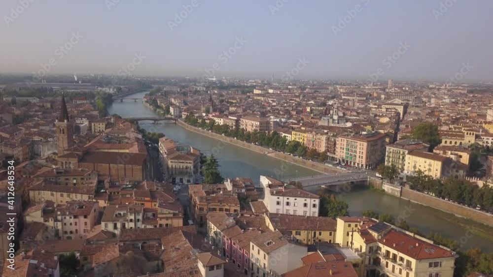 Aerial view of famous touristic city Verona in Italy in the morning.The drone approaches the river Adige, the typical Italian apartment rooftops and bridge Ponte Pietra. Video in 4K Aerial view of famous touristic city Verona in Italy in the morning.The drone approaches the river Adige, the typical Italian apartment rooftops and bridge Ponte Pietra. Video in 4K