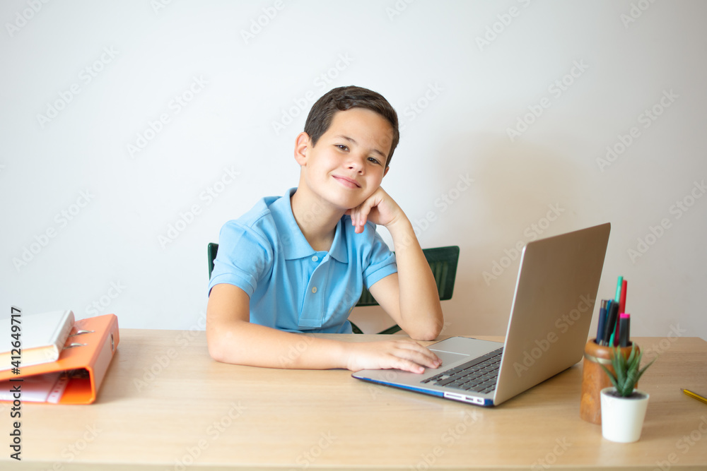 Young boy smiling and watching laptop in the classroom.A young boy student typing computer for learning online at his home. Young boy smiling and watching laptop in the classroom.A young boy student typing computer for learning online at his home.