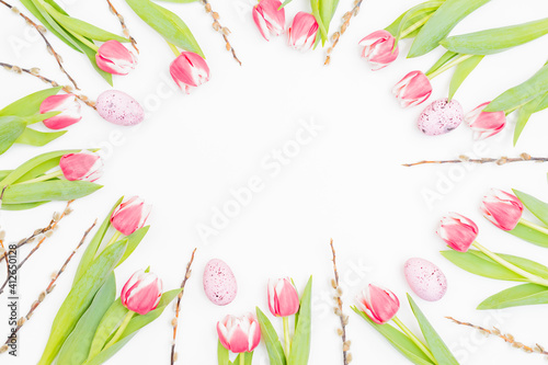 Flat lay easter composition with pink tulips and eggs on white background