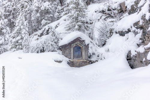 A small shrine during the ski touring in the mountains and forest above Alvaneu in the Swiss Alps © gdefilip