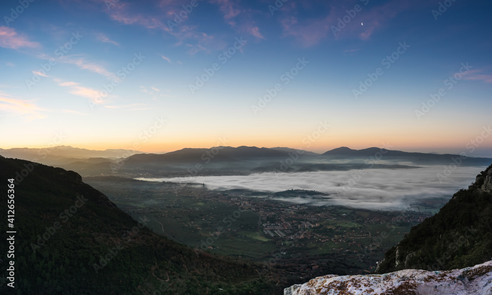 Sunrise from the top of the mountain with fog on the valley, Terni, Umbria, Italy