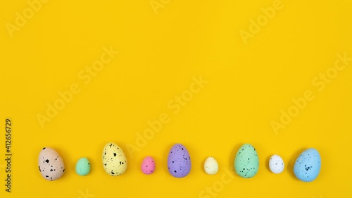 Animation of a little chicken jumping on colored eggs on a yellow background
