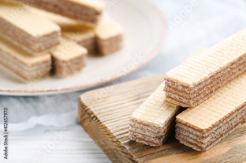 Sweet wafer sticks on white wooden background