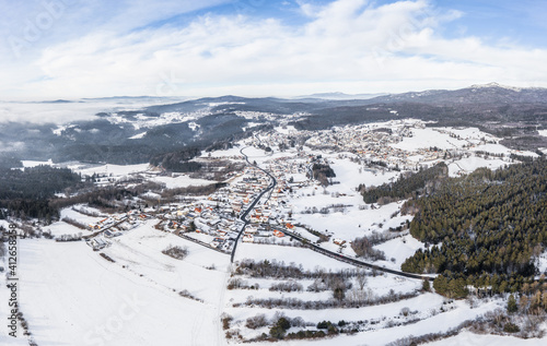 Bild einer Luftaufnahme mit einer Drohne der Ortschaft Riedelhütte im bayerischen Wald mit Bergen Arber Rachel und Lusen im Winter mit Schnee und Eis, Deutschland photo