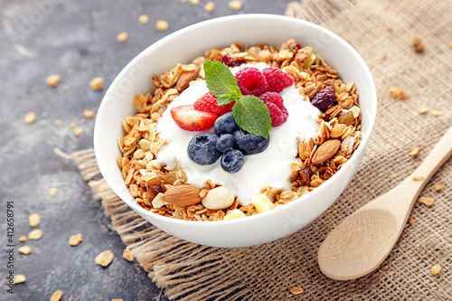 Tasty granola with fresh berries on grey background