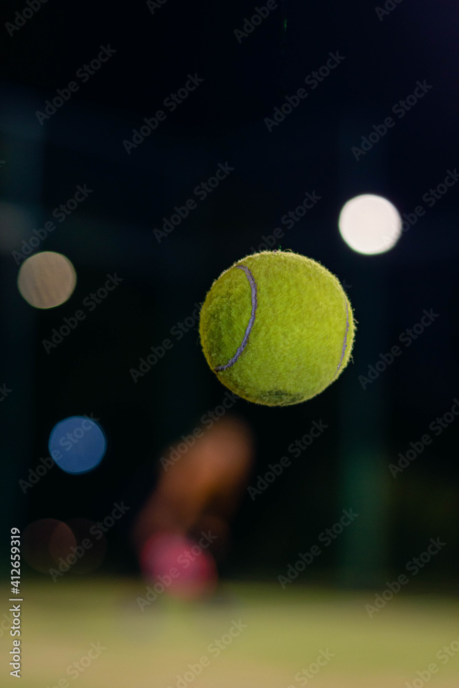 green tennis or paddle ball and court net with selected focus at high speed