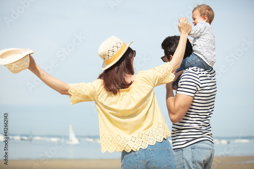portrait of young happy parents with child at the beach