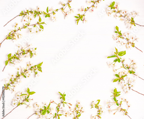 Spring branches of blossoming cherry in the form of a frame on a white background.