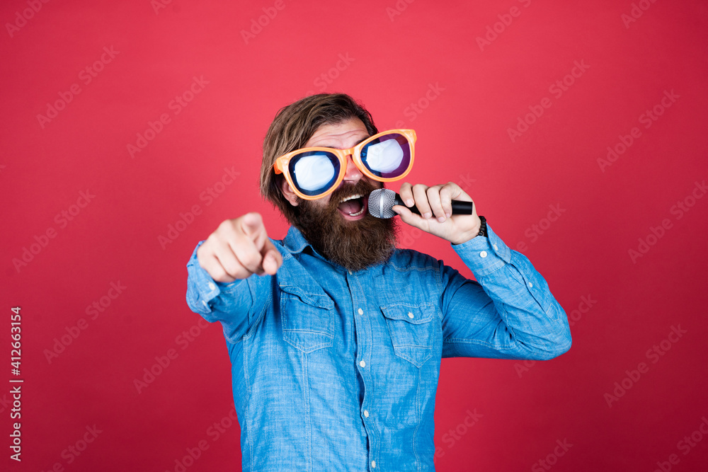 mature bearded guy has long hair wearing party glasses and singing in mic, vocal mature bearded guy has long hair wearing party glasses and singing in mic, vocal